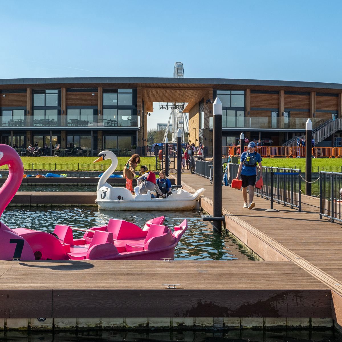 People getting on a pedalo in front of Willen Lake's Watersports Centre