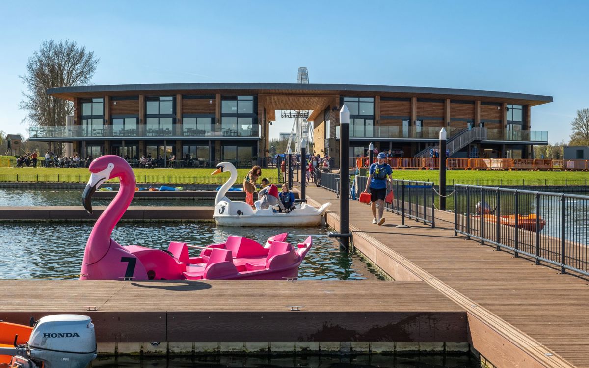 People getting on a pedalo in front of Willen Lake's Watersports Centre