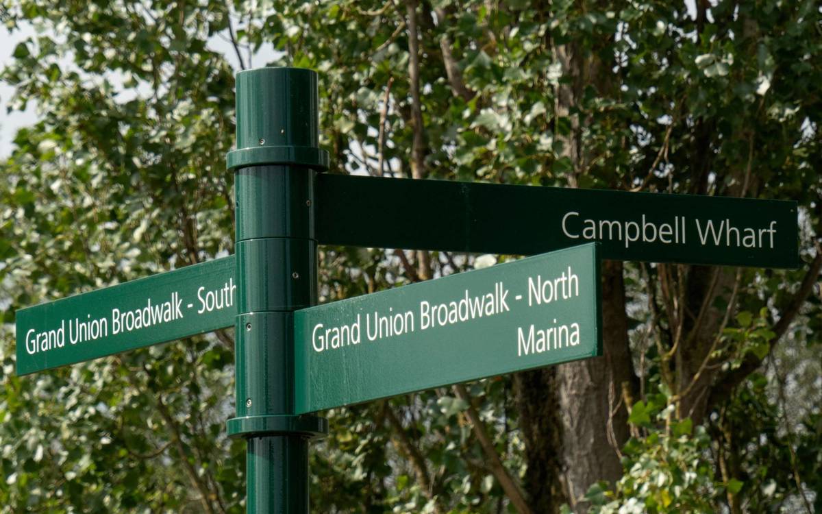 Green and white signage directing to Campbell Wharf Marina and local parkland